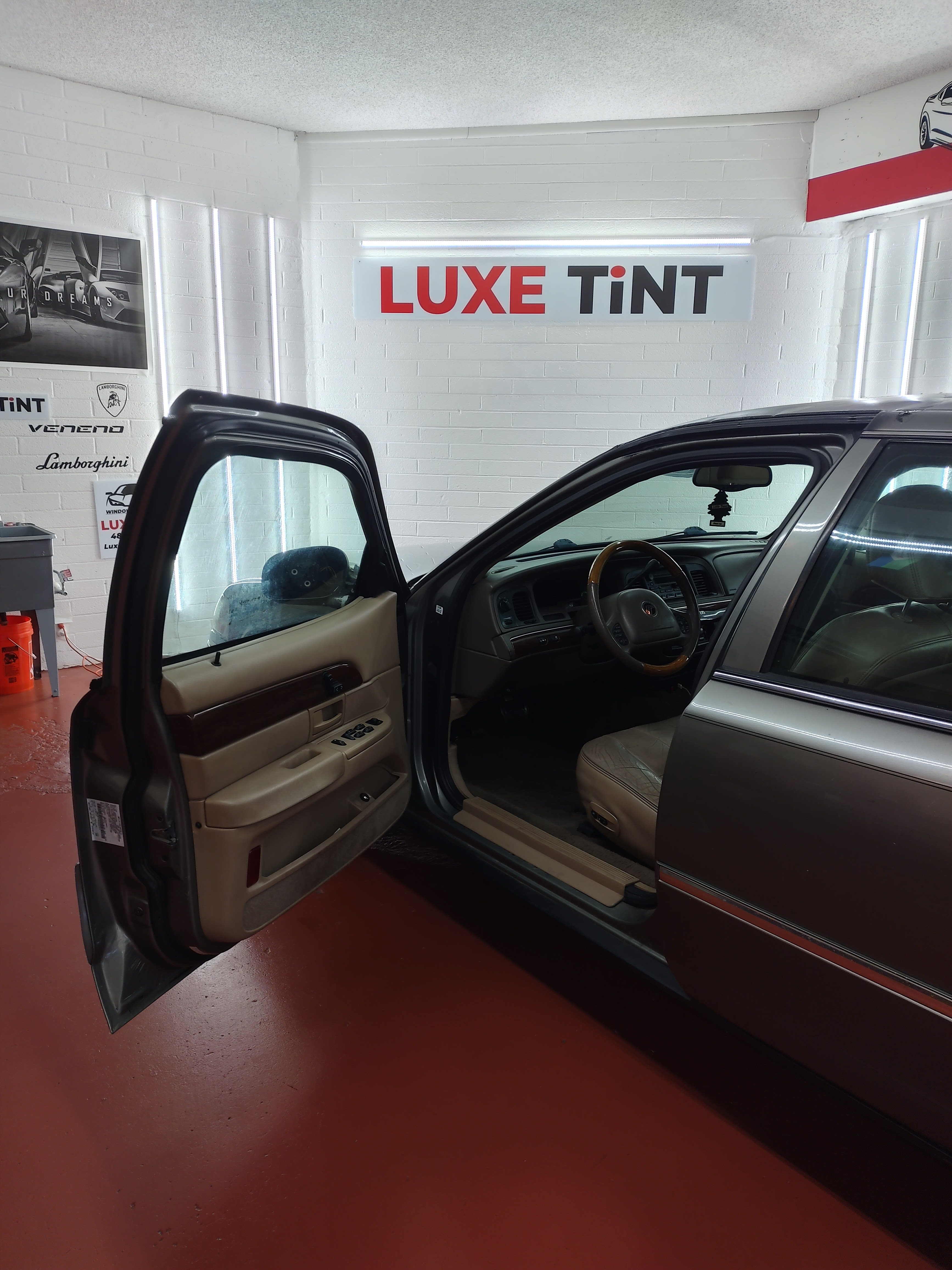Tan Buick sedan, door open with shop sign