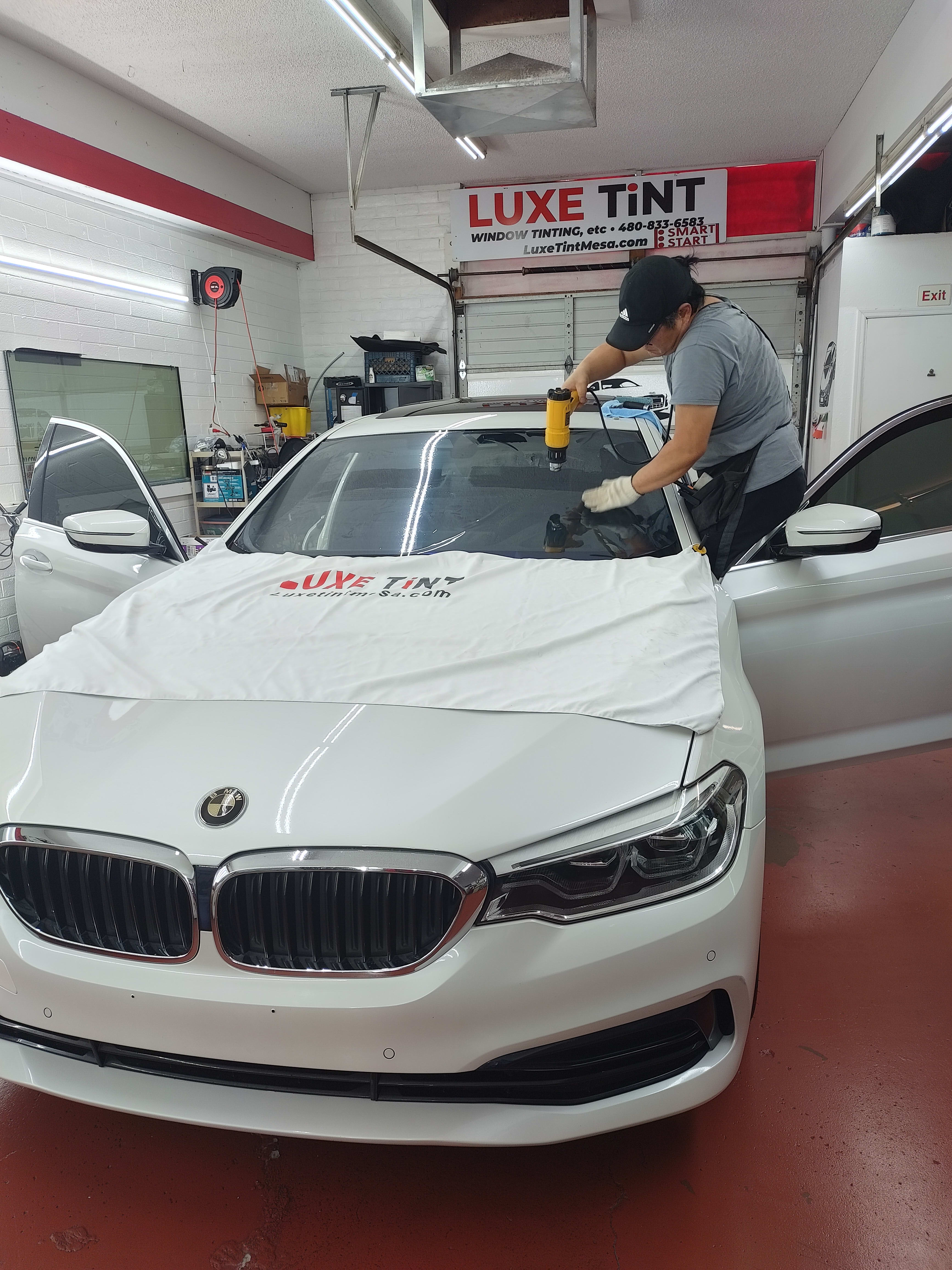 White BMW 5 Series, front, windshield prep