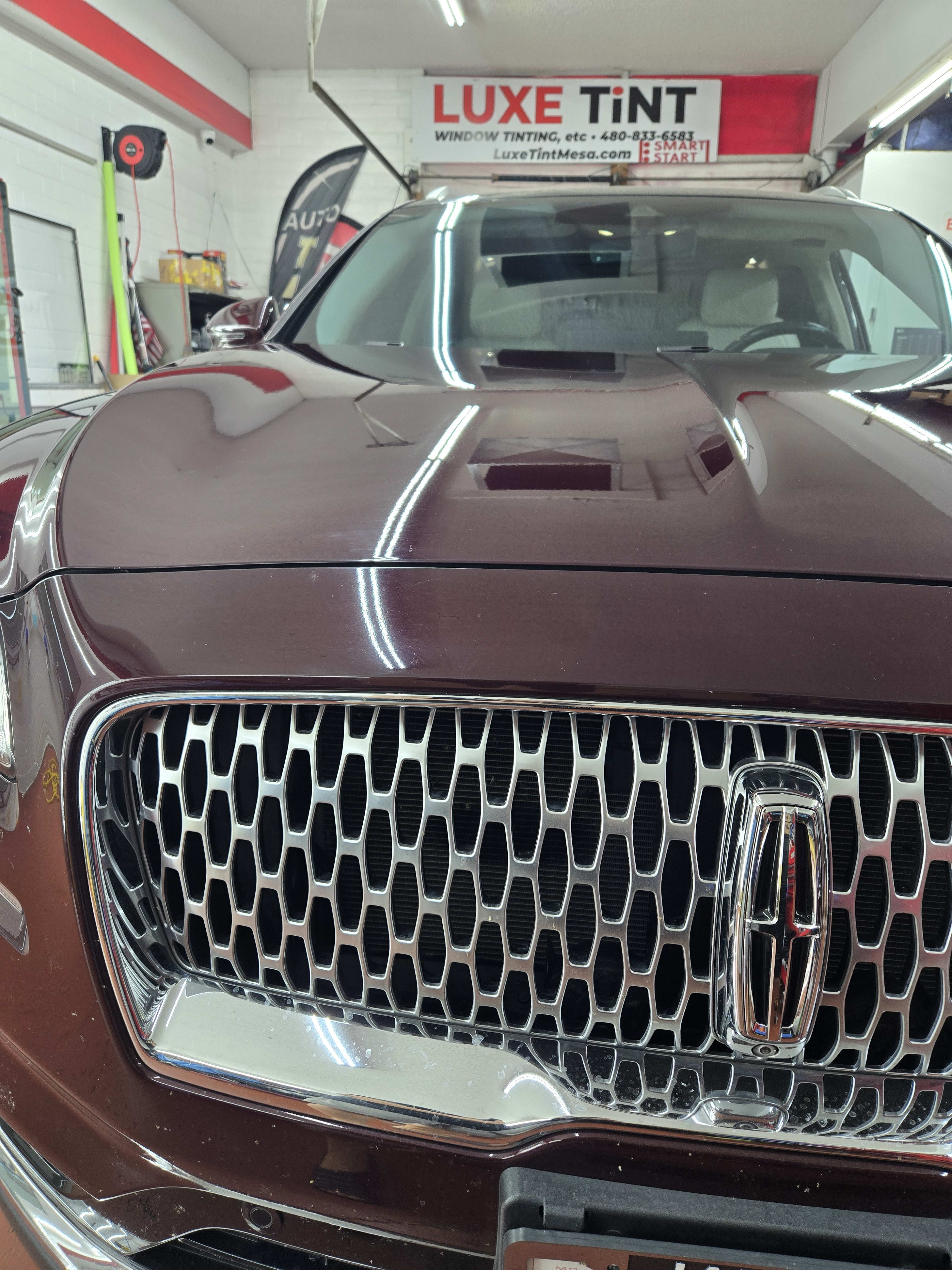 Maroon Lincoln sedan, front grille