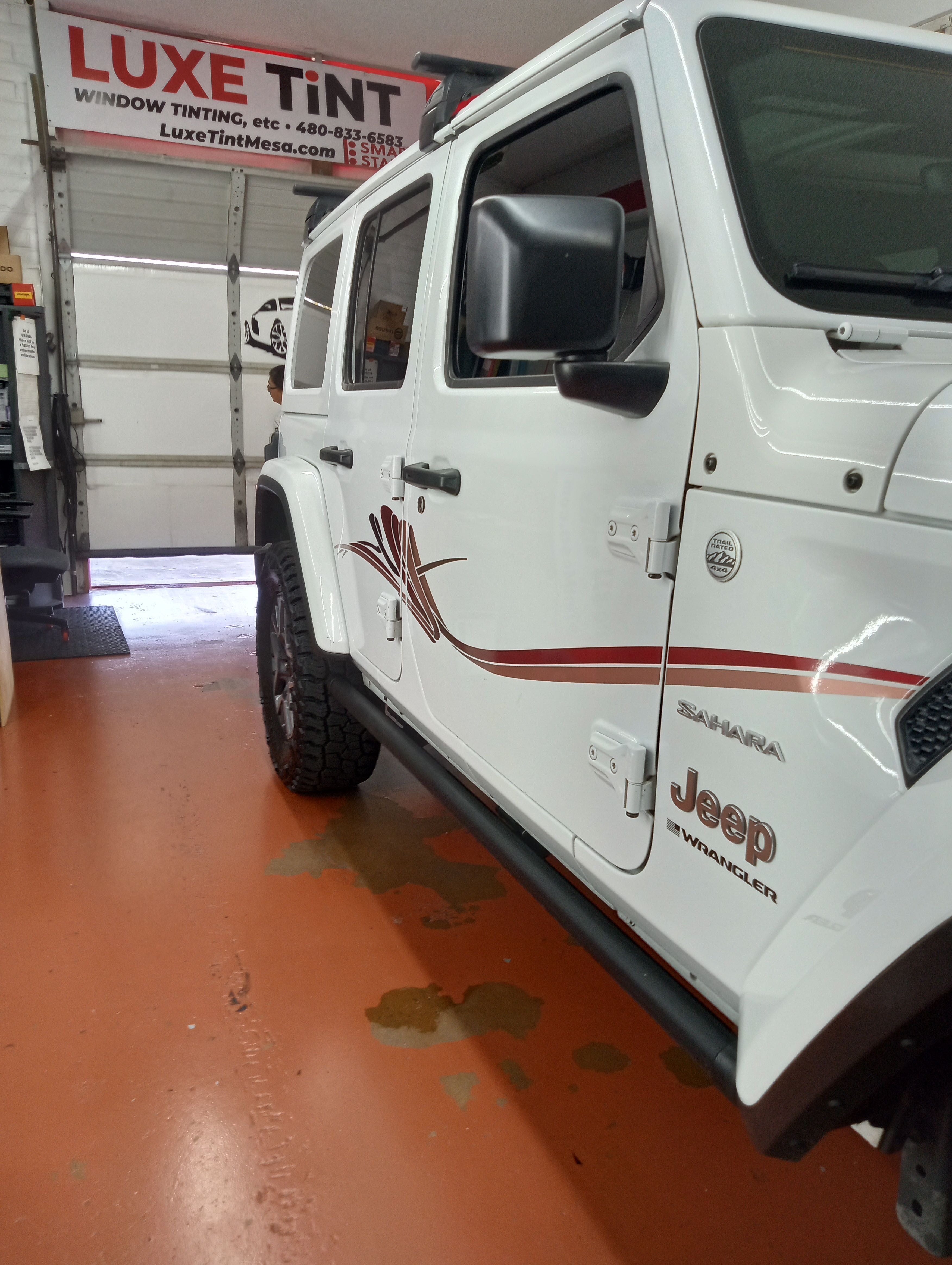 White Jeep Wrangler Sahara, side with sign