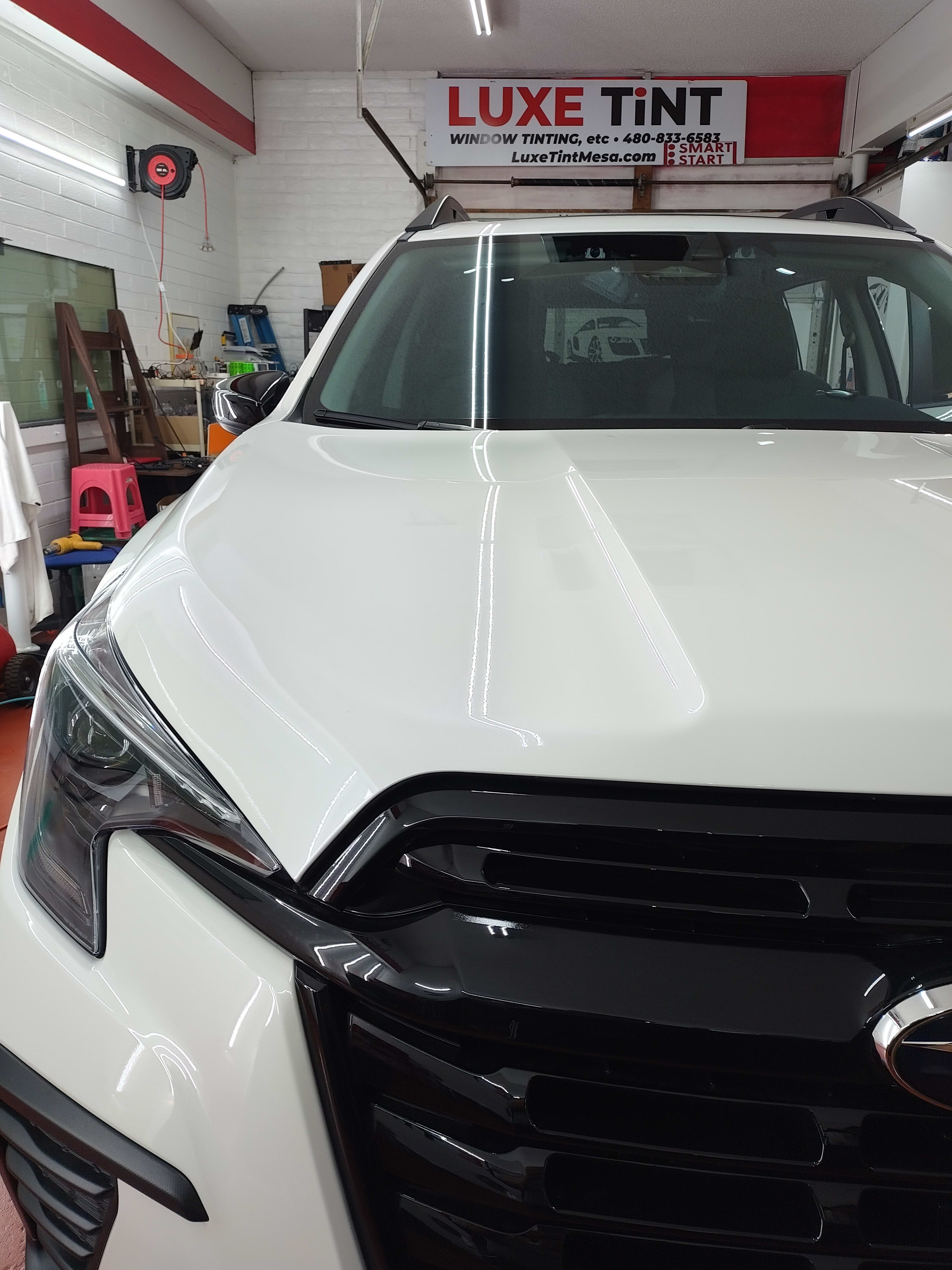 White Subaru Ascent, front, shop sign
