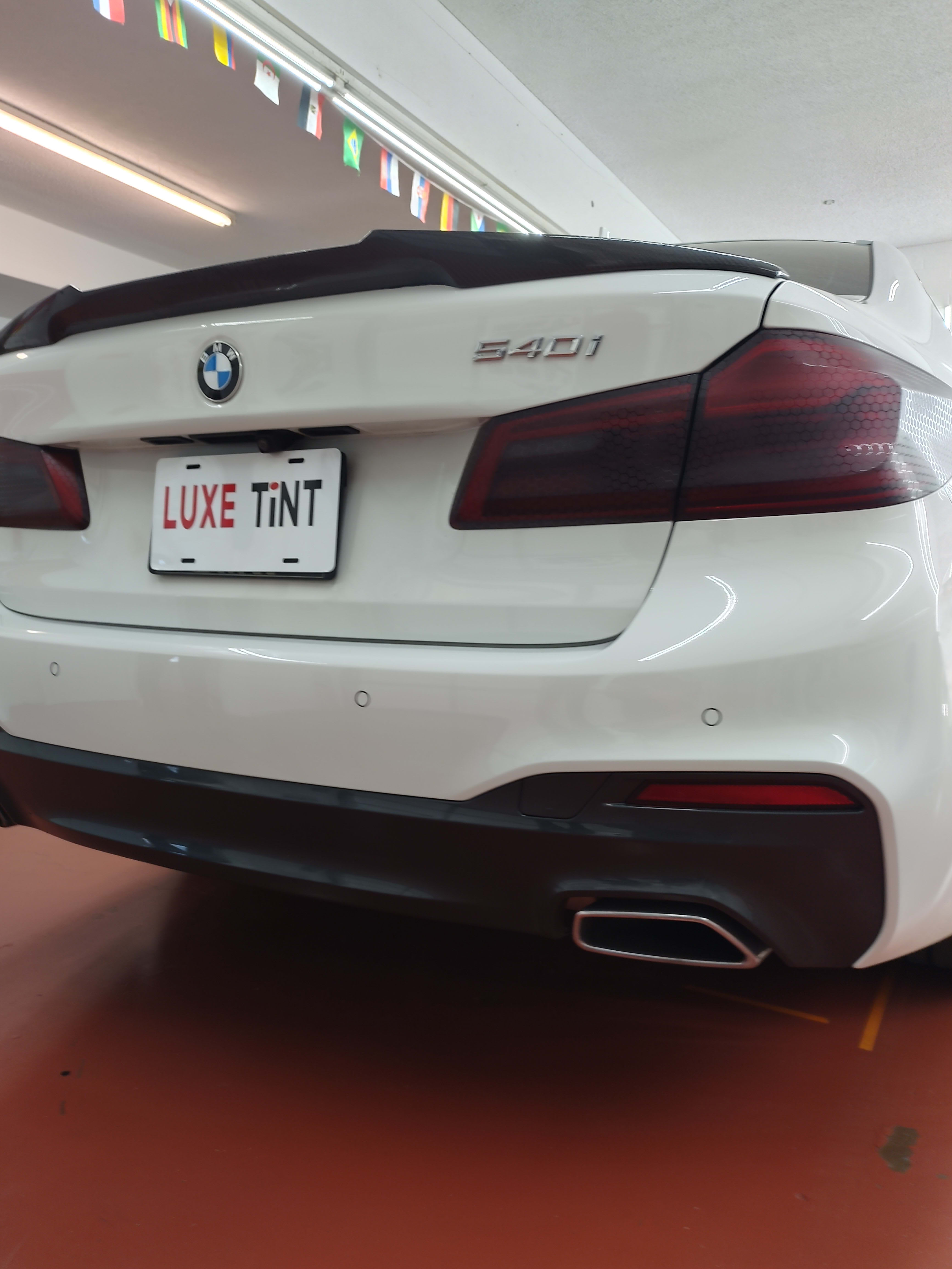 White BMW 540i, rear with Luxe Tint plate