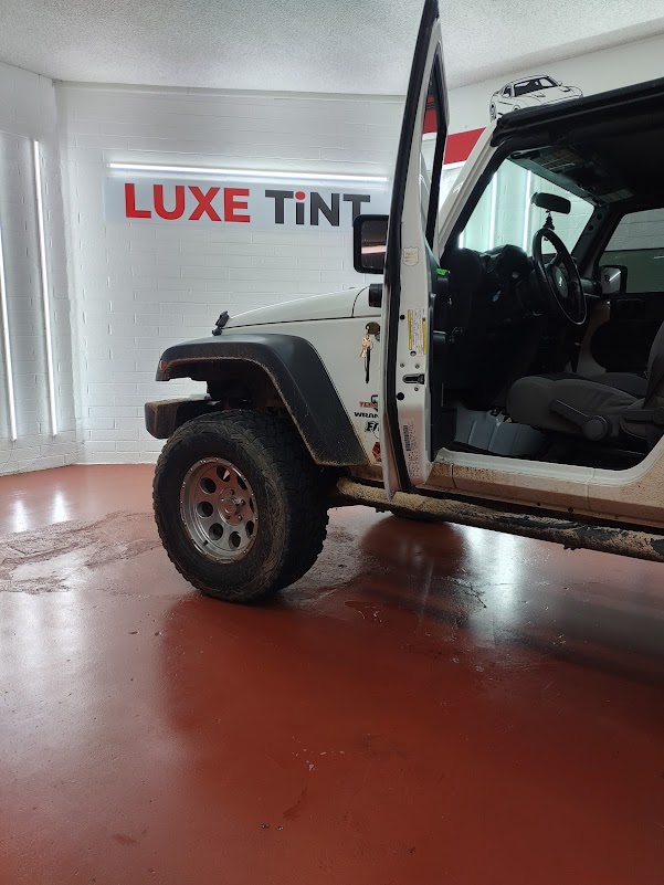 White Jeep Wrangler, door open, shop sign
