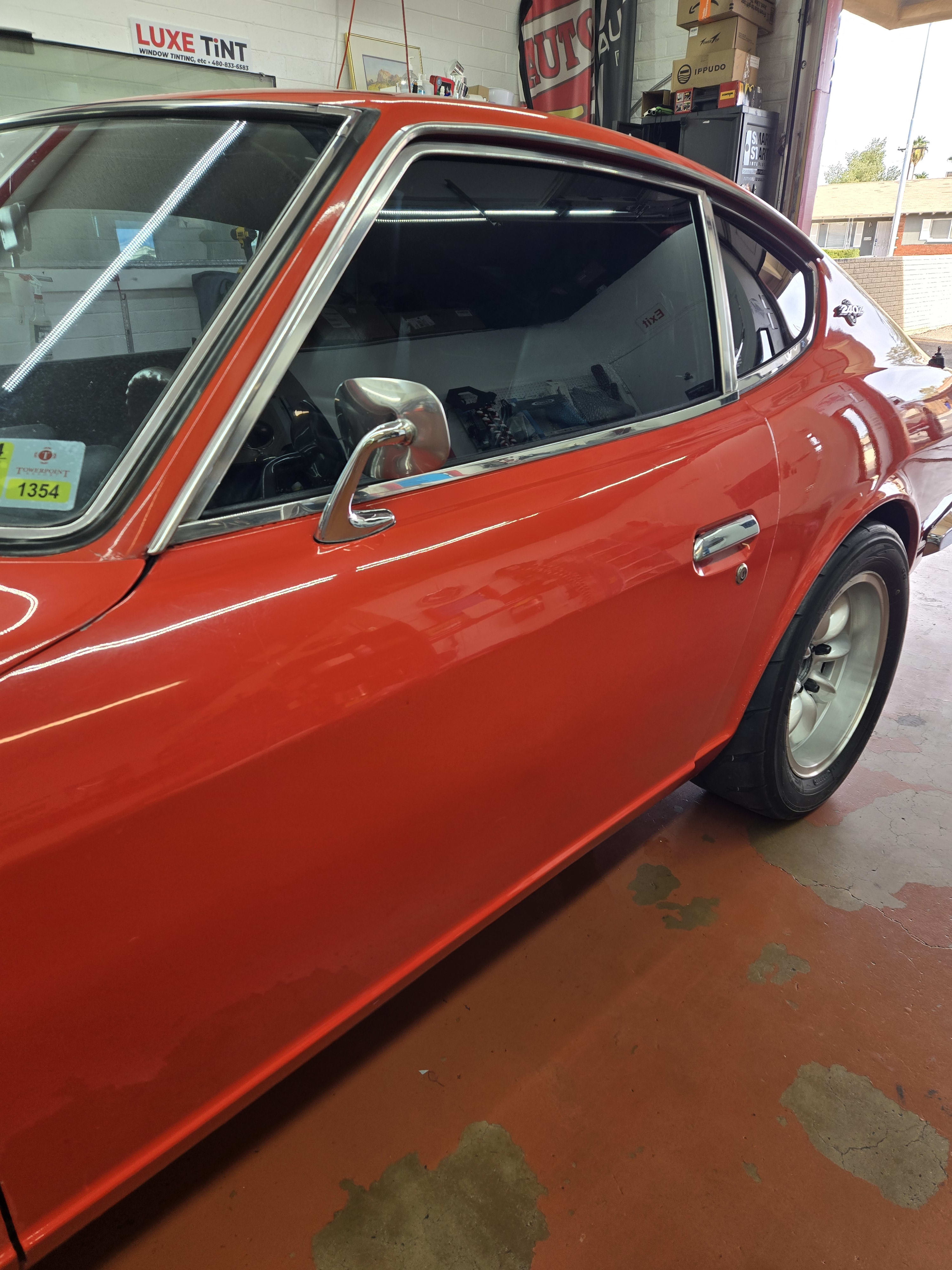Orange Datsun 240Z, side with shop sign