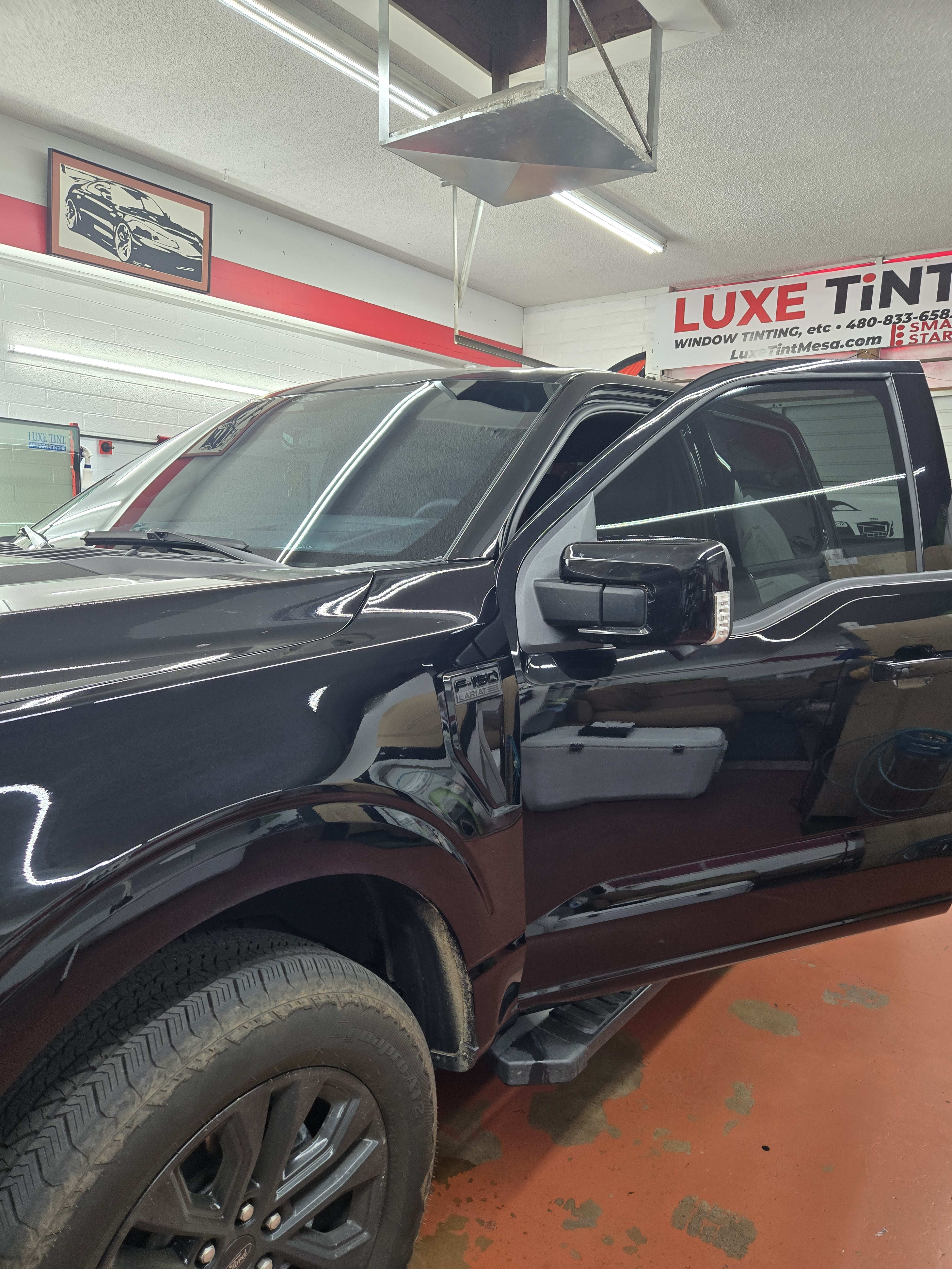 Black Ford F-150, side with shop sign