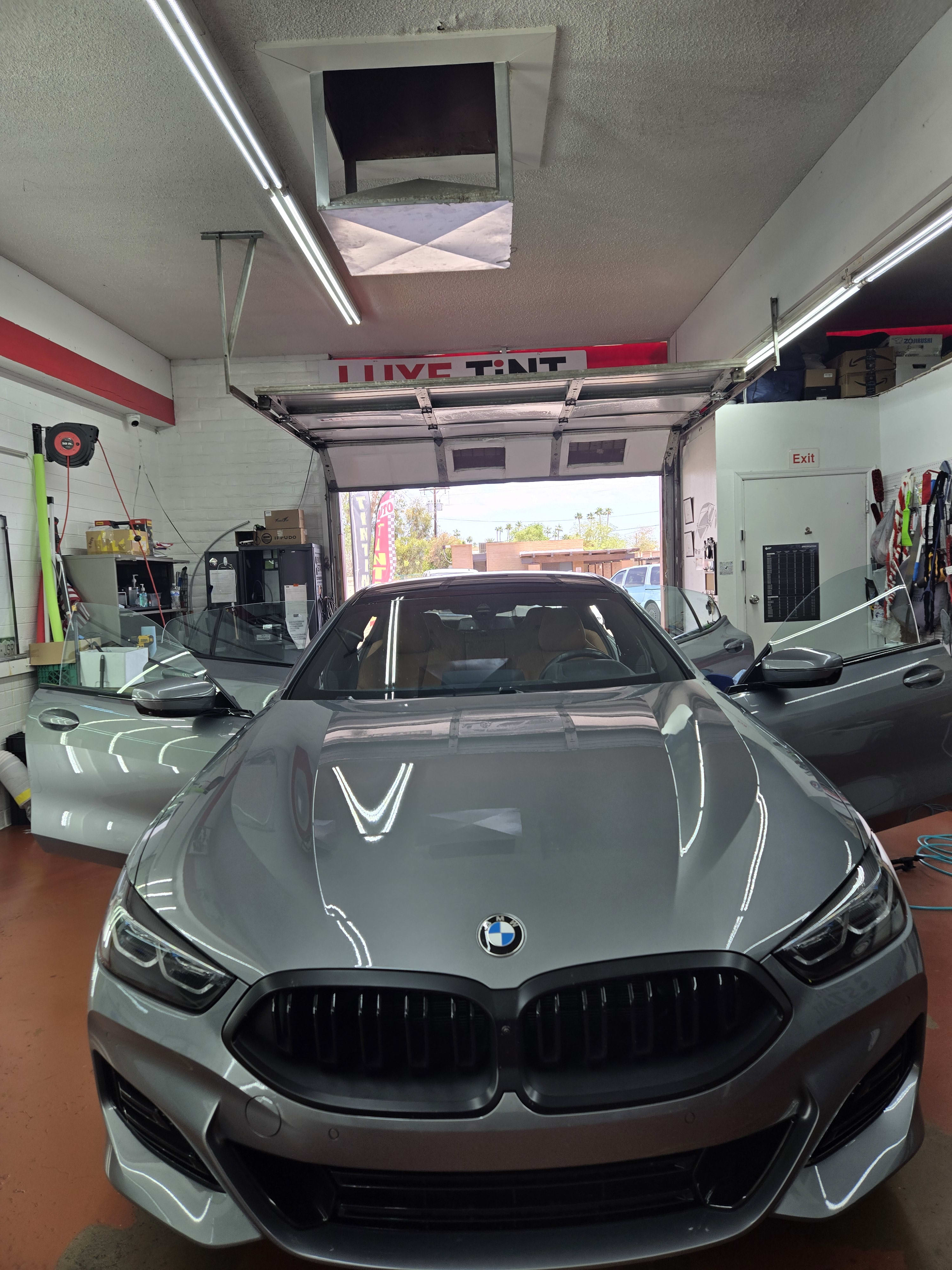 Grey BMW 8 Series, front with shop sign