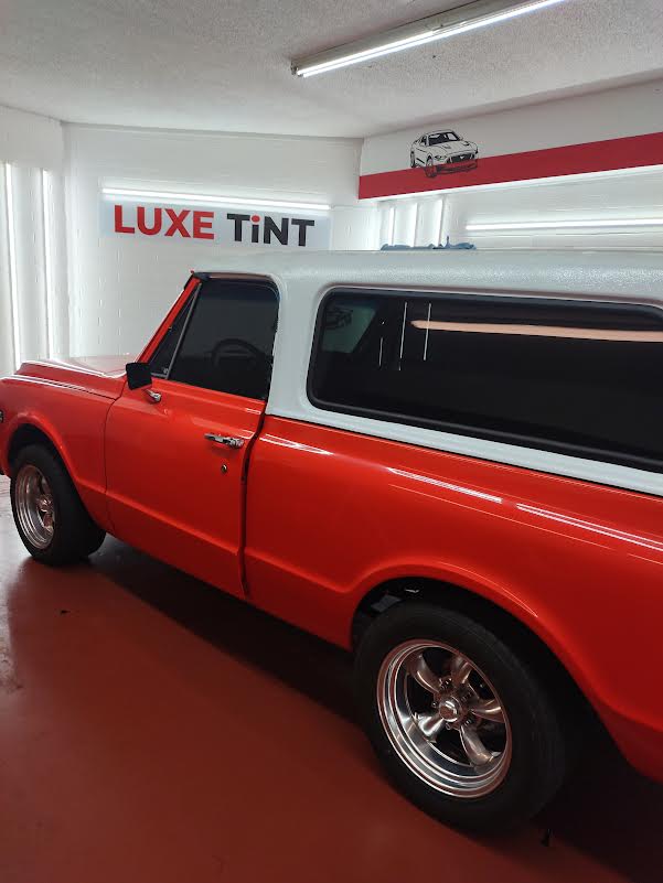 Orange Chevy C10 with camper shell, side