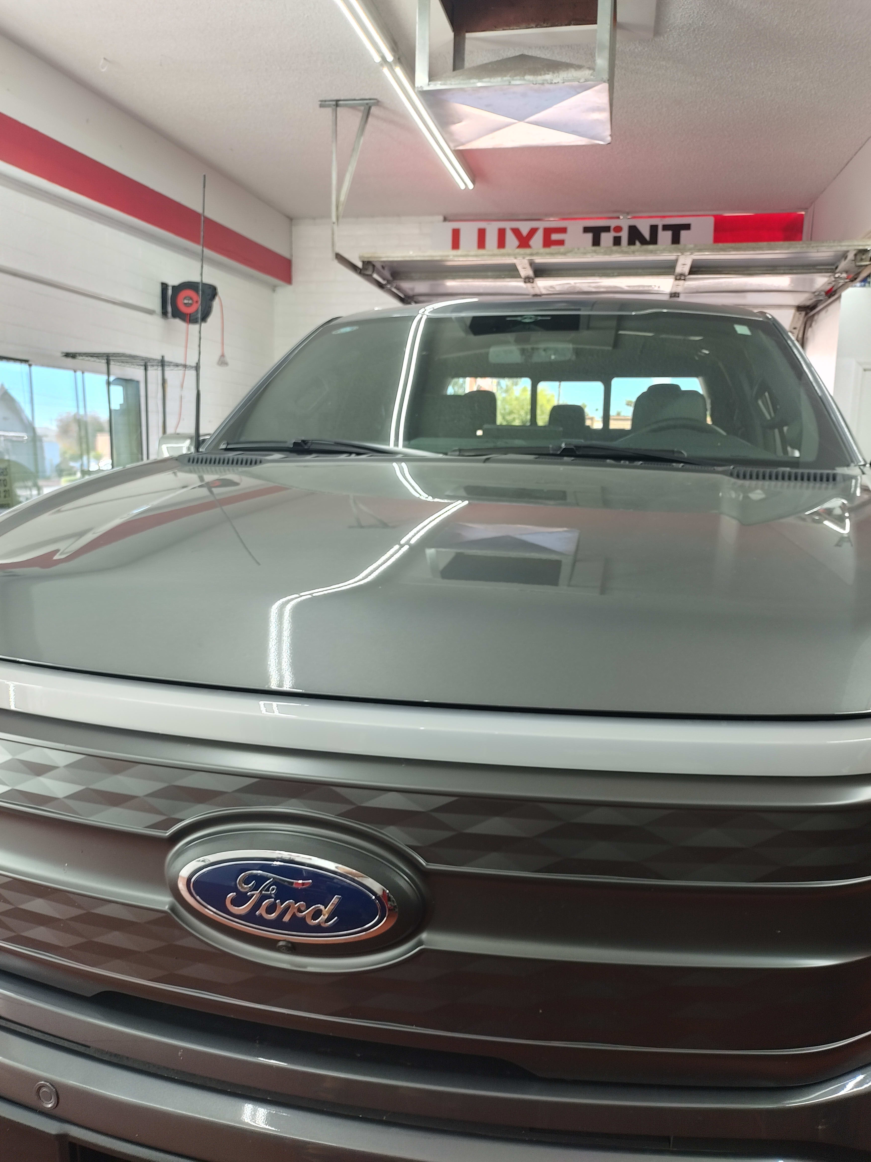 Gray Ford F-150 Lightning, front, shop sign