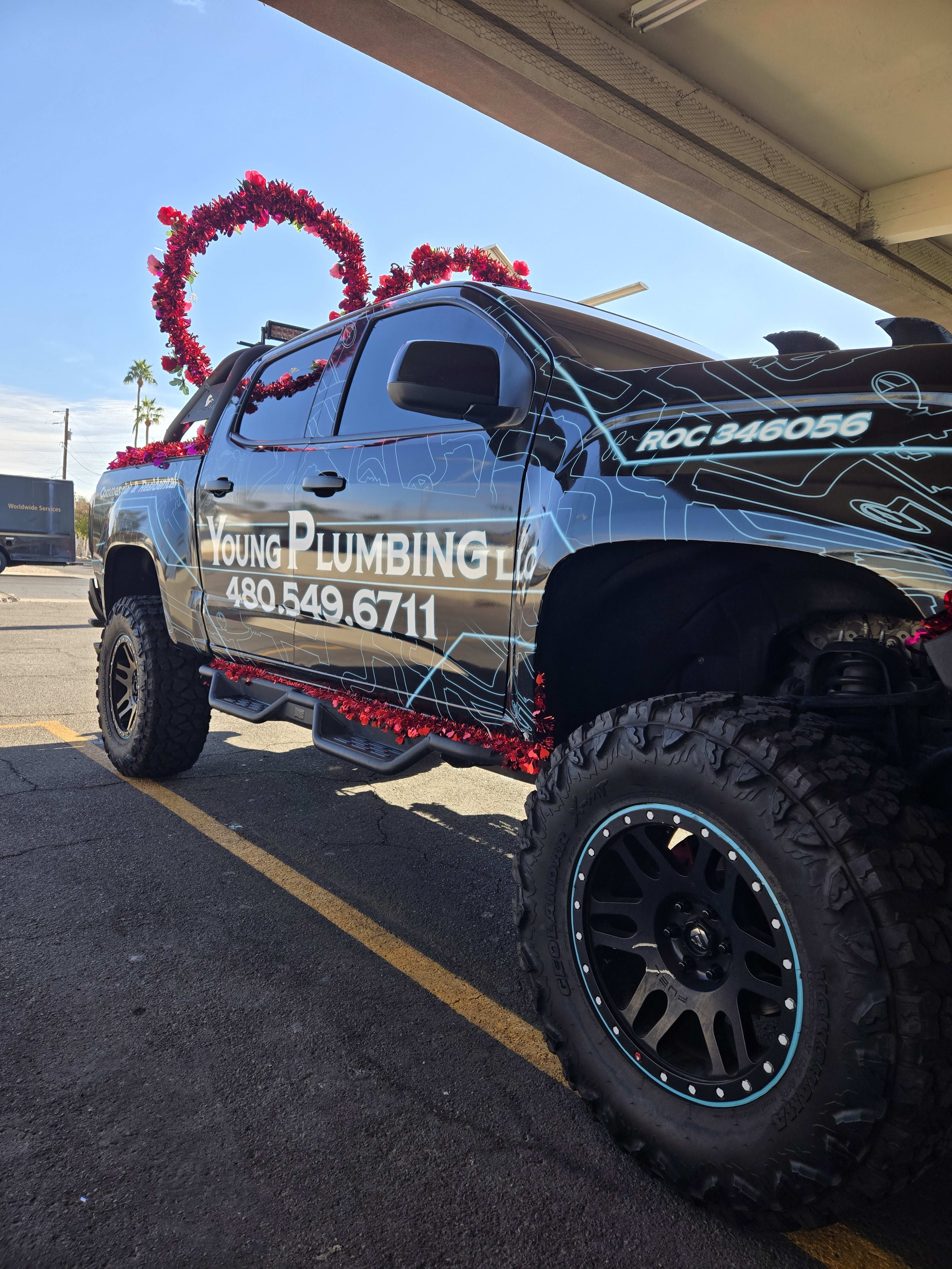 Black lifted Chevy truck, outside shop