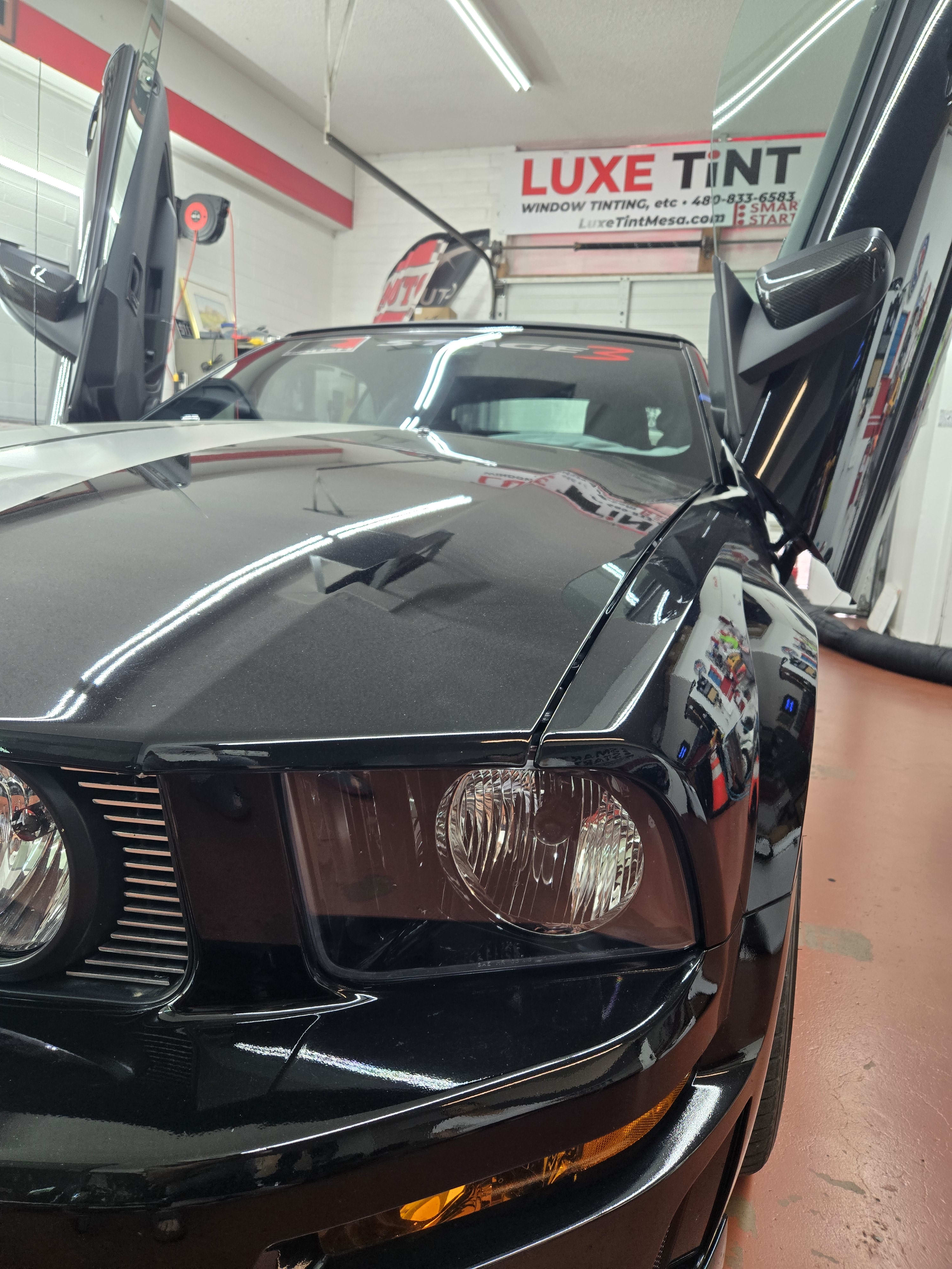 Black Ford Mustang, front with door open