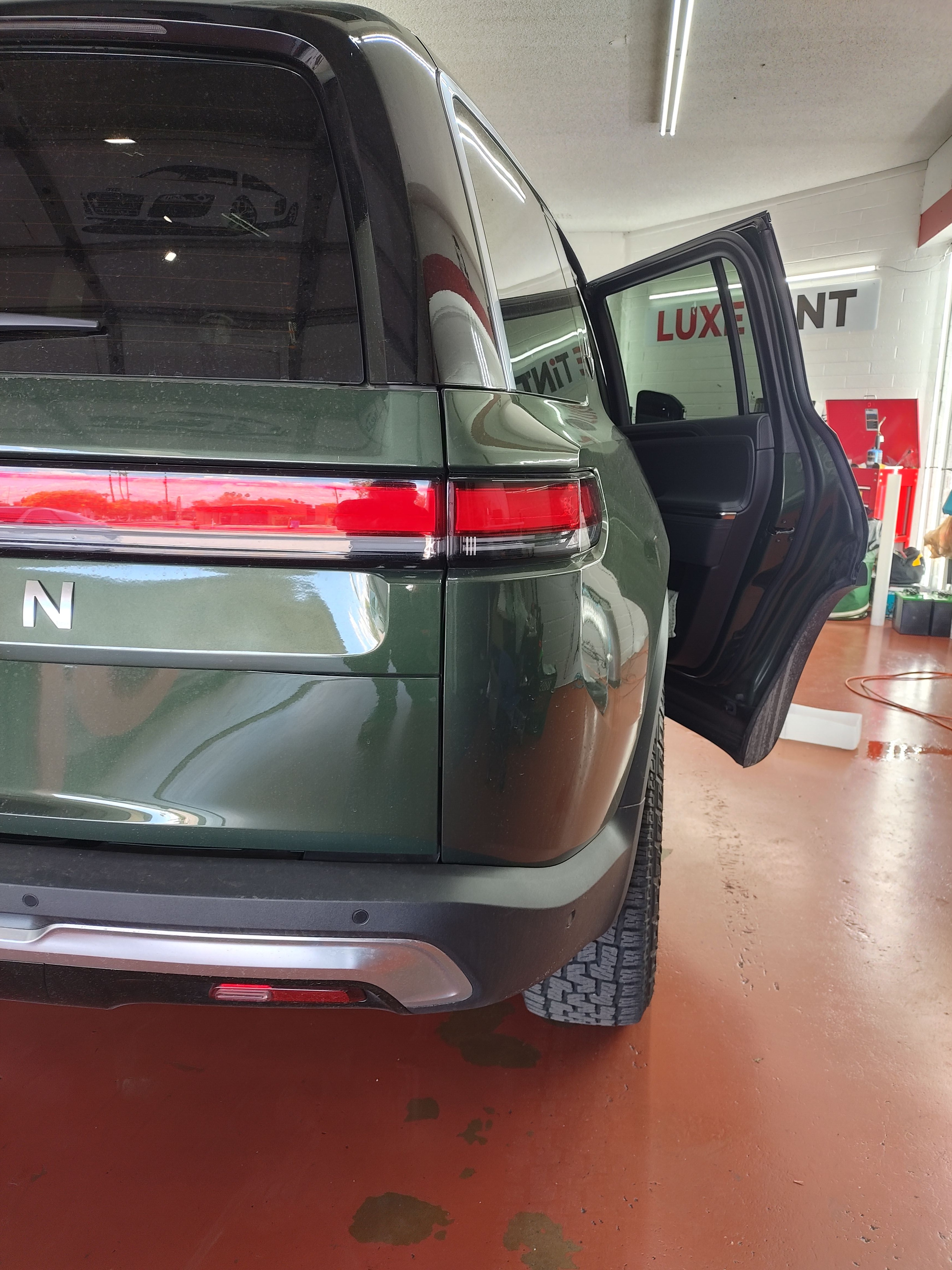 Dark green Rivian R1S, rear three-quarter